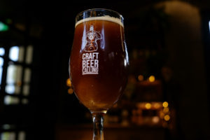 Image show a glass of stout beer in a Craft Beer Calling glass