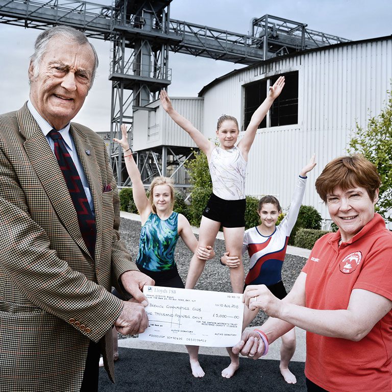 Simpsons Malt employee handing cheque to Berwick gmynastics club