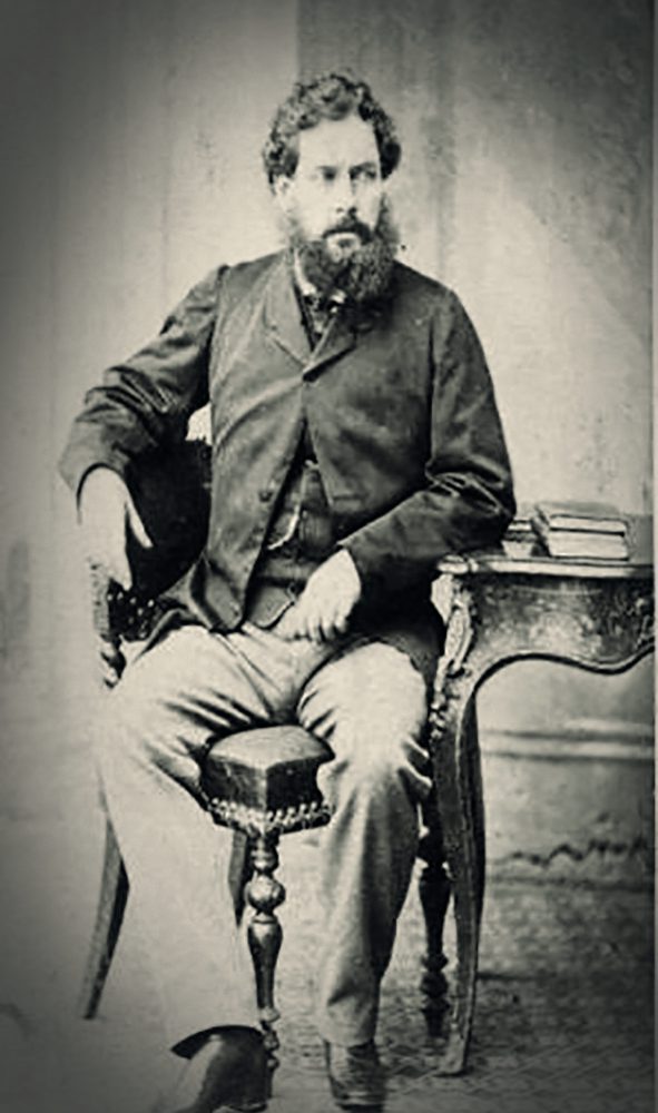 Black and white image of Richard L. Simpson sat at a desk